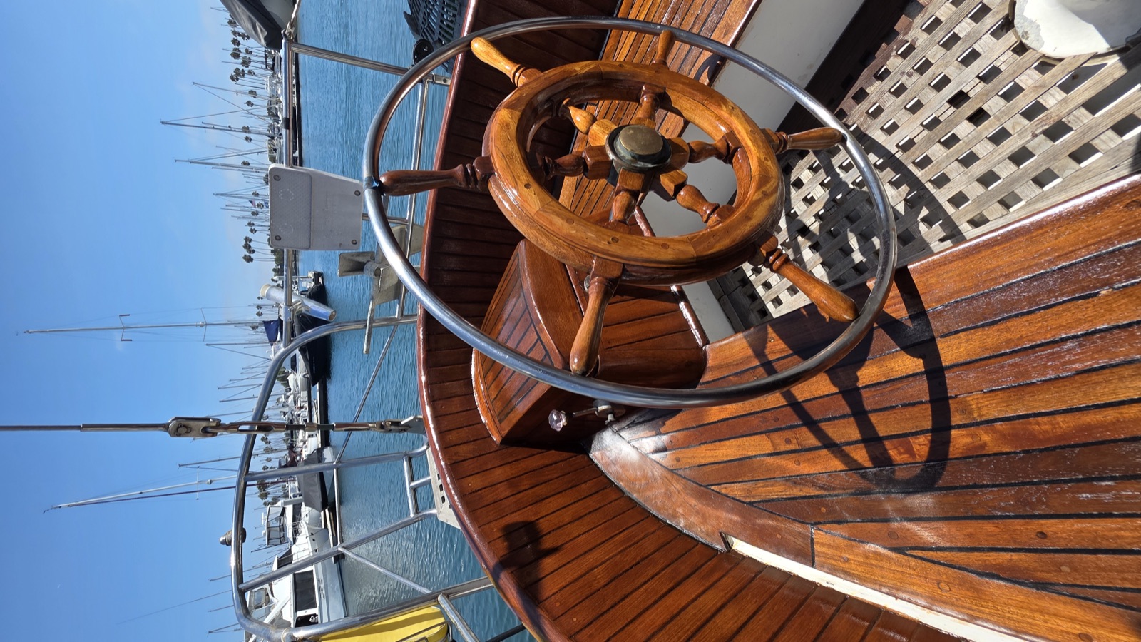 Restored ship's wheel and teak deck at the marina