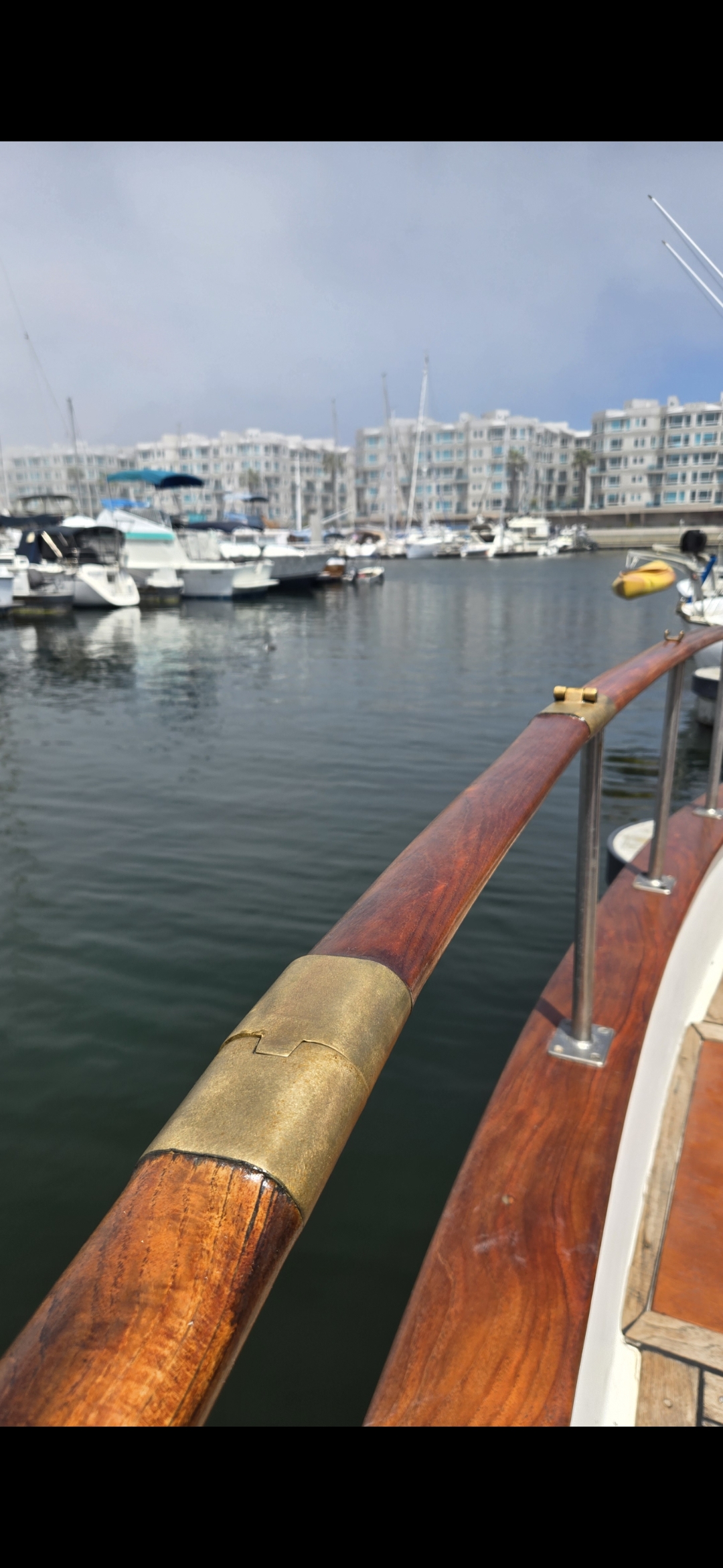 Teak caprail with brass fitting and marina