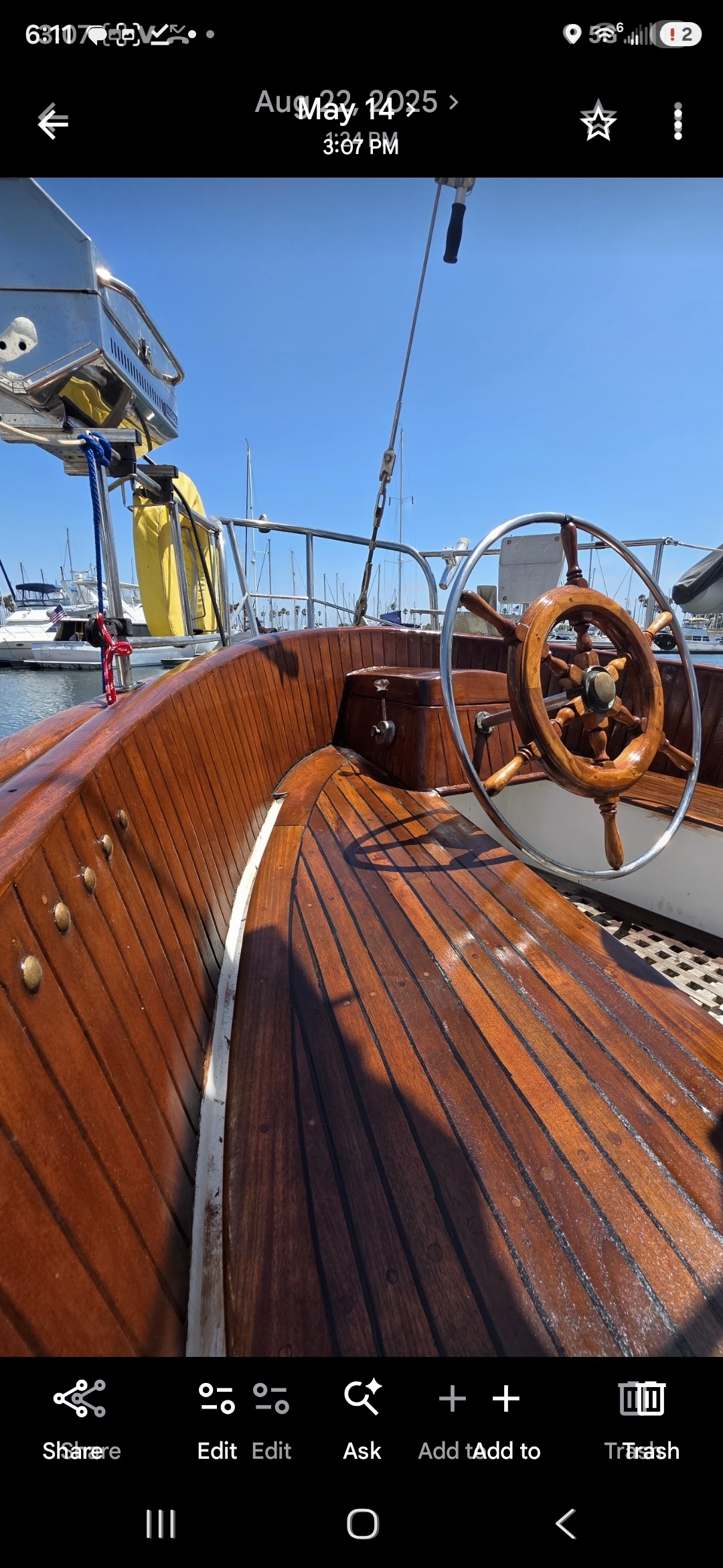 Teak cockpit and wooden helm wheel under blue sky