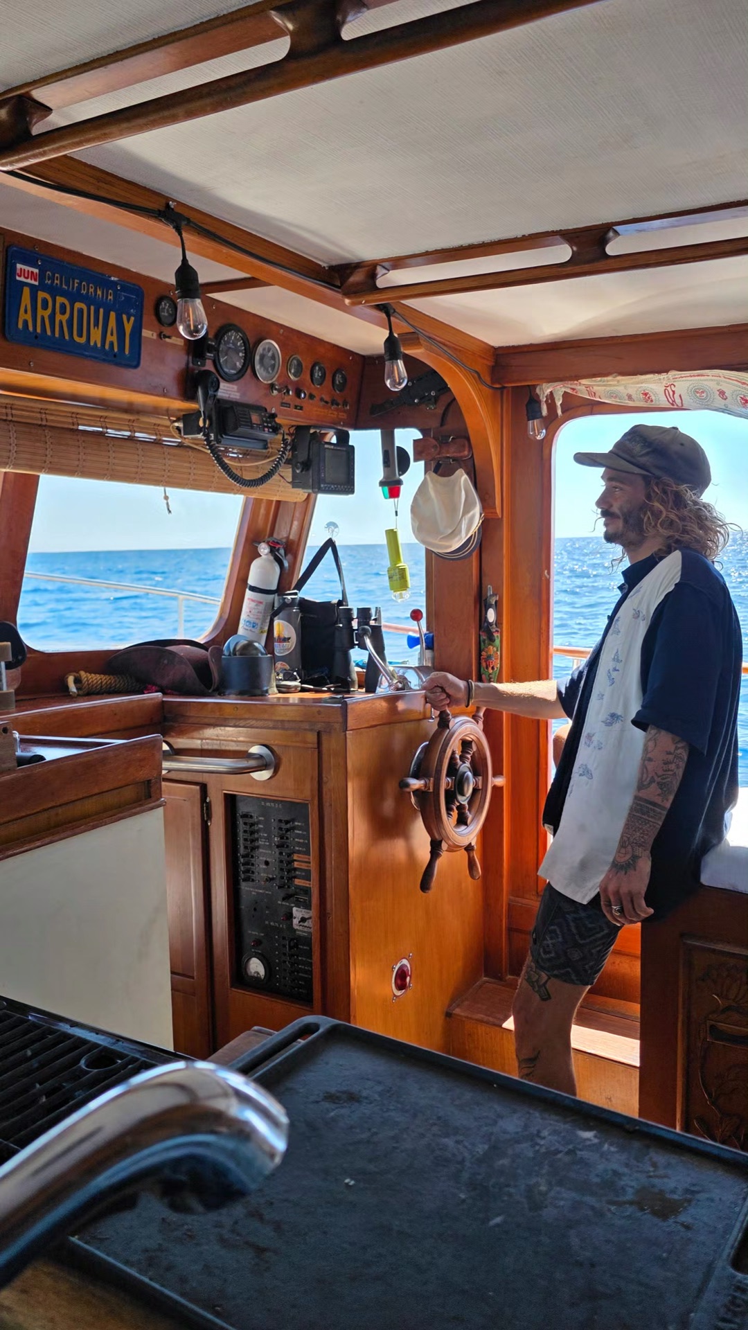 Taylor at the helm of a classic wooden boat